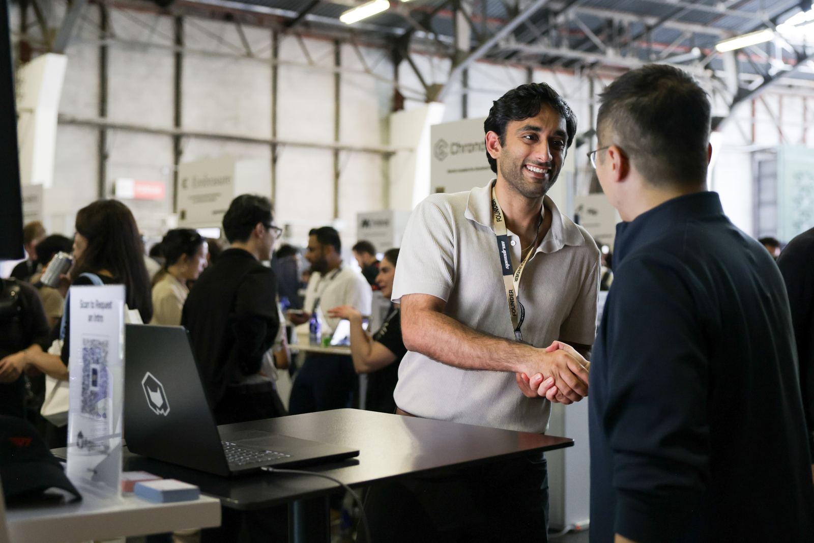 A founder shaking hands with an investor after Demo Day